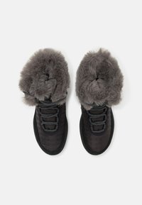 Svarte støvler med en teksturert overdel, grå faux fur-fôr, grå snøringer og en tykk gummisåle. Designet for varme og komfort.