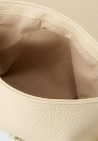 Borsa a tracolla beige dalla trama morbida con interno liscio, caratterizzata da un rivestimento in tessuto delicato e una forma arrotondata, completata da una chiusura con zip.