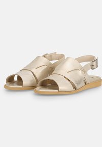 Helle goldene Leder-Sandalen mit offener Zehe, überkreuztem Design und Riemen hinten. Sie verfügen über eine flache Sohle und eine dezente, strukturierte Oberfläche.