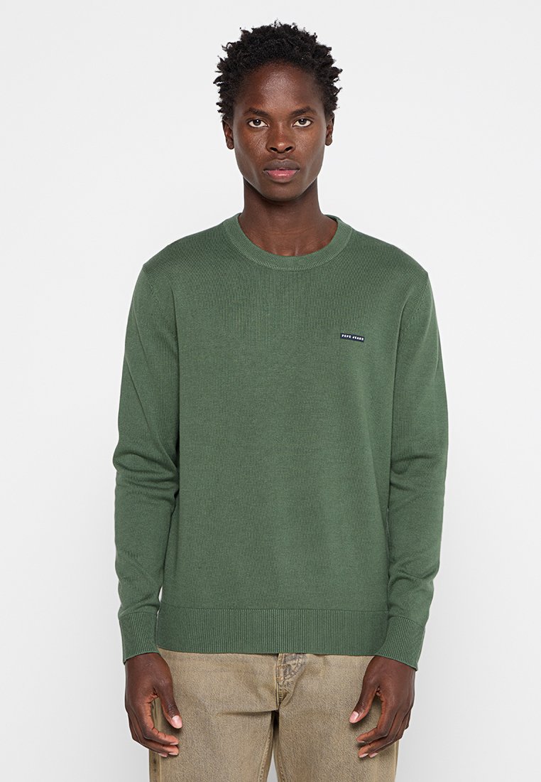 Pull à côtes vert avec un col rond et une petite étiquette de logo sur la poitrine. Fabriqué en tissu texturé, il présente des poignets et un ourlet ajustés.
