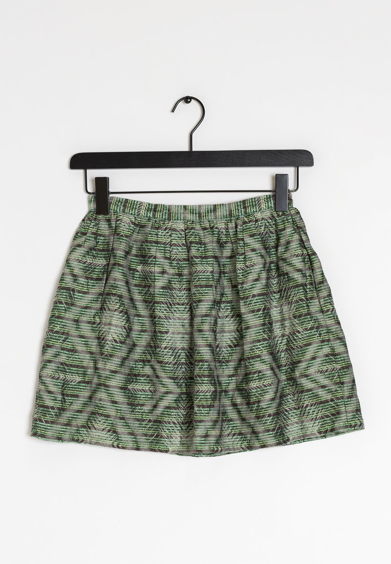 Green and black patterned skirt with elastic waistband hanging on a black hanger against a white background.