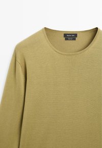 Olivegrüner Langarm-Strickpullover aus Baumwolle mit Rundhalsausschnitt, zeigt Schulter- und oberen Brustbereich, mit dem Etikett "Massimo Dutti".