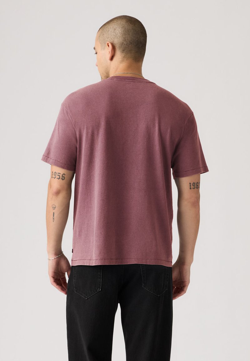 T-shirt à manches courtes et col rond en coton rose poussiéreux avec une coupe décontractée, doté d'un ourlet droit et de détails de couture minimalistes.