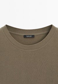 T-shirt in cotone verde oliva con scollatura tonda e maniche corte, caratterizzato da una texture sottile e un'etichetta che recita "Massimo Dutti."