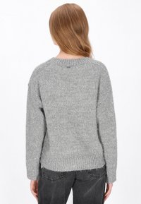 Szary sweter dzianinowy z okrągłym dekoltem, długimi rękawami i luźnym fasonem, wykonany z miękkiej, teksturowanej przędzy, z delikatnym rozcięciem na dolnym końcu.