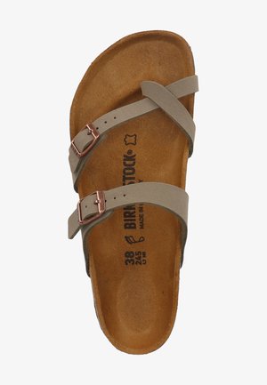 Grijze leren sandaal met twee kruisbandjes en een koperen gesp. Gecontourde kurken voetbed met gegraveerde merk- en maatdetails. Zachte textuur.