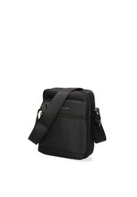 Borsa a tracolla nera realizzata in tessuto testurizzato. Presenta una tracolla removibile, scomparti con cerniera e un logo discreto sul fronte.