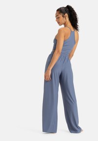 Ensemble deux pièces à rayures bleu clair comprenant un débardeur ajusté à fines bretelles et un pantalon large avec une taille élastique.