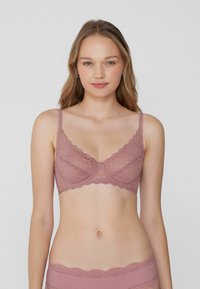 Krajková podprsenka v jemné mauve barvě s vlnkovými okraji a nastavitelnými ramínky. Obsahuje květinový vzor a klasický design s kosticemi.