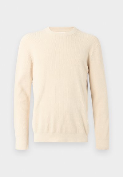 Pull à manches longues en tricot côtelé de couleur crème, avec encolure ronde et poignets ajustés, présenté sur un fond blanc uni.