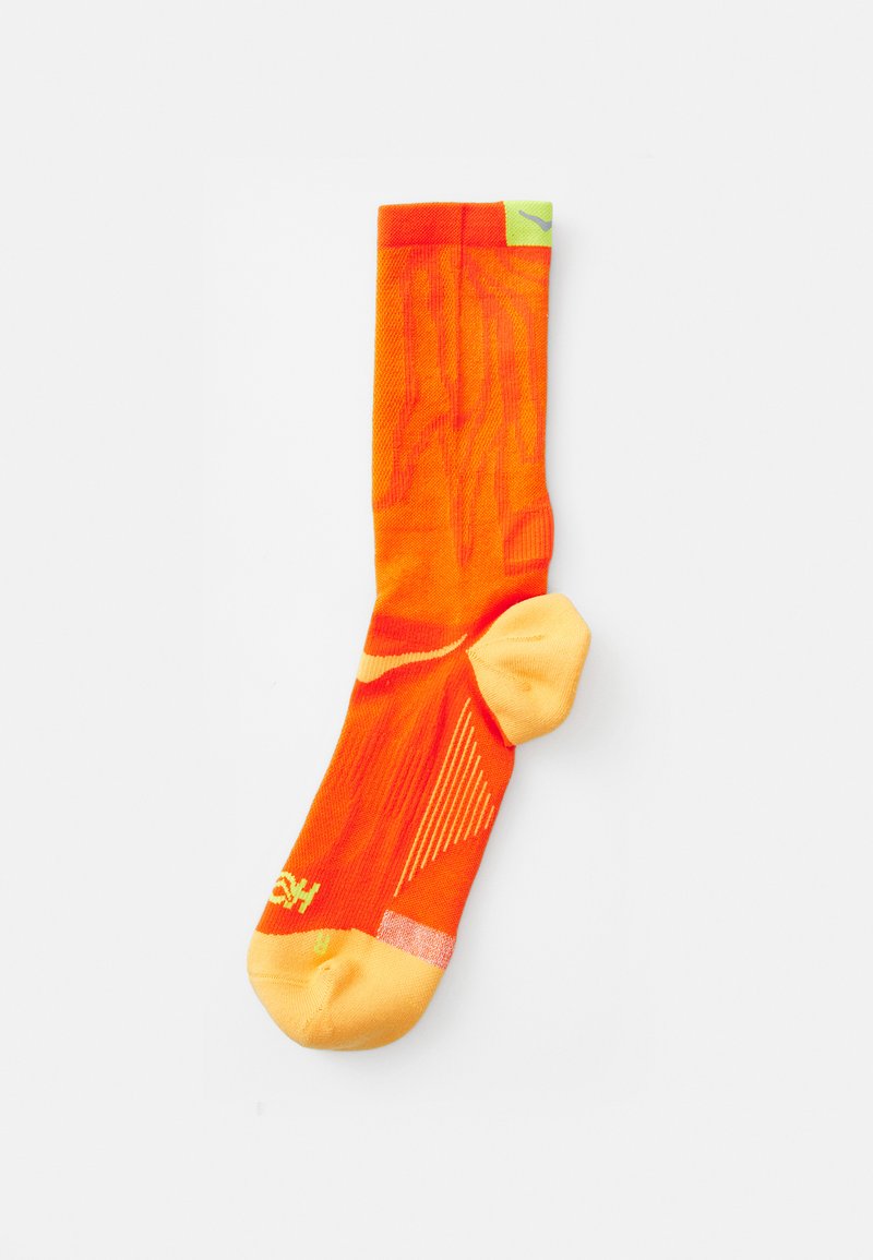 Ergonoomne heledat sokid eredast oranžist värvist, helekollase varba ja kannaosa ning tekstuuriga mustrid ja diagonaalsed jooned haardeks ja stiliseerimiseks.