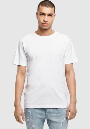 Weißes Baumwoll-T-Shirt mit Rundhalsausschnitt und kurzen Ärmeln, kombiniert mit hellblauen, verwaschenen Jeans. Einfaches Design ohne Muster.