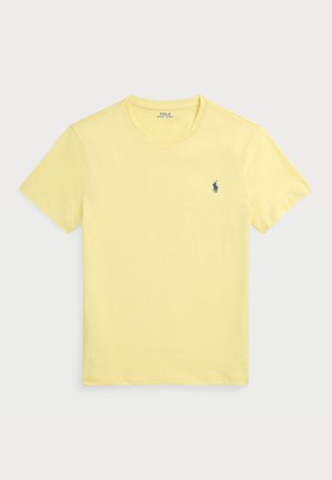 Rumena bombažna majica s kratkimi rokavi in okroglo ovratnikom, s malim mornarsko modrim logotipom na levi strani prsnega dela.