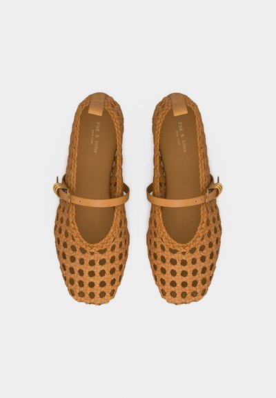 Ζευγάρι δερμάτινα μπεζ Mary Jane παπούτσια με διακριτικά πλέγματα, ρυθμιζόμενα λουράκια με αγκράφα και τετράγωνα μύτη, σε λευκό φόντο.