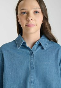 Lichtblauwe denim overhemd met een knoopsluiting, een normale kraag, subtiele glinsteraccenten en een ontspannen pasvorm met lange mouwen.