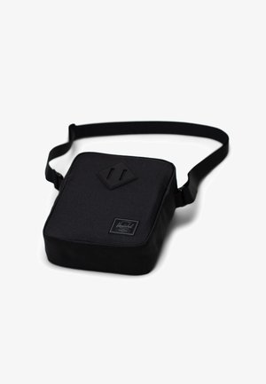 Černá taška přes rameno čtvercového tvaru, s texturovaným povrchem, nastavitelným popruhem a embosovanou nášivkou loga vpředu.