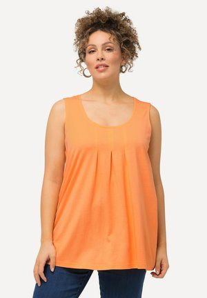 Top arancione senza maniche in tessuto morbido con scollatura rotonda e dettagli plissettati nella parte frontale, abbinato a jeans blu scuro.
