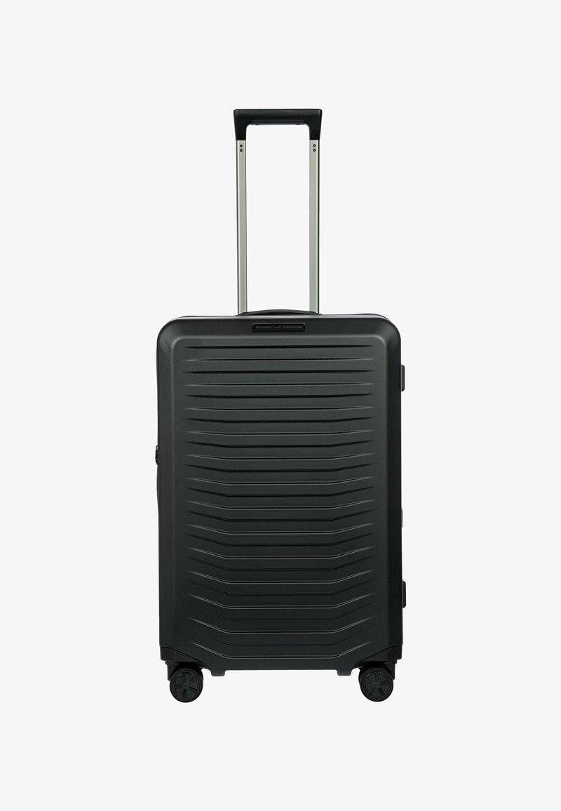 Valigia rigida nera con righe orizzontali, manico retrattile e quattro ruote. Texture liscia, forma rettangolare, minimalismo hardware.