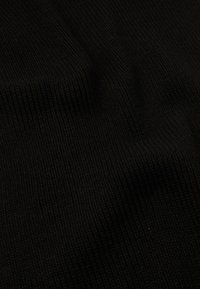 Sort tekstureret stof med vandret ribbing, der har en blød, let elastisk følelse og en ensartet, jævn overflade.