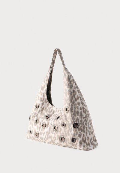 Τσάντα από μαλακό ύφασμα με απαλό λεοπάρ σχέδιο, που διαθέτει πολλαπλές μεταλλικές τρύπες διασκορπισμένες στην επιφάνεια και έναν ενιαίο ιμάντα ώμου.