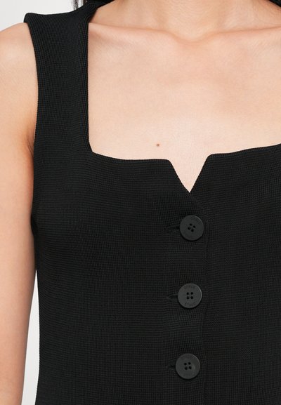 Black sleeveless top with a square neckline, textured fabric, and four circular buttons down the front.