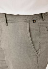 Helle graue Hose aus strukturiertem Material, mit zwei Seitentaschen, einem Knopfverschluss und einem kleinen schwarzen LOGO-Label.