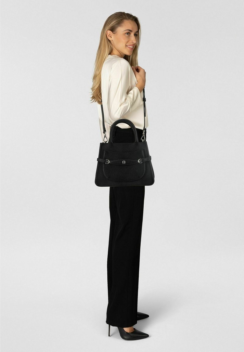 Bolso de cuero negro con acabado texturizado, doble asa y correa ajustable. Cuenta con herrajes de tono plateado y una solapa frontal con cierre.