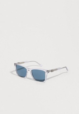 Gafas de sol rectangulares transparentes con lentes azules, que cuentan con montura de plástico transparente y detalles metálicos plateados en las patillas.