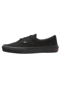Černé plátěné tenisky s tkaničkami, nízký střih, gumová podrážka a malé bílé logo na boku. Mají hladkou texturu a minimalistický styl.