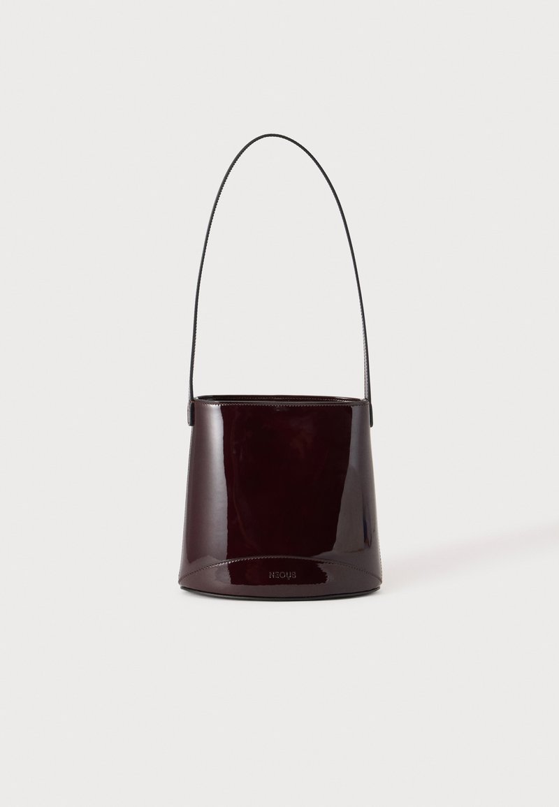 Sac seau brun foncé brillant avec une longue sangle fine et des coutures visibles minimales sur un fond clair.