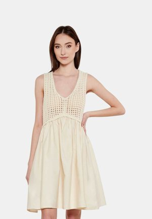 Vestido color crema con corsé de ganchillo, escote en v profundo y falda acampanada con textura. El diseño sin mangas mejora la transpirabilidad.
