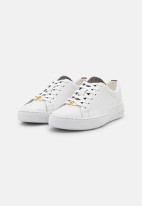 Sneakers bianchi in pelle con una finitura liscia, dotati di dettagli in metallo dorato e di un tessuto grigio testurizzato attorno alla caviglia per un tocco di eleganza.