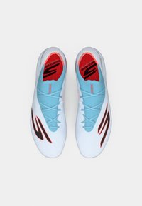 Sapatos de desporto azul claro com um upper texturizado, interior vermelho, detalhes em preto no logo e atacadores azul claro, desenhados para performance.