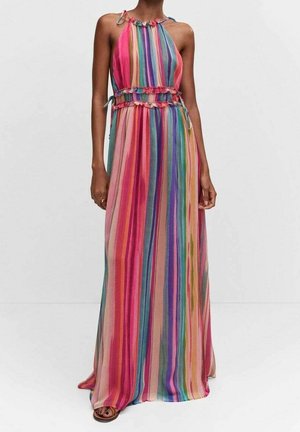 Kobieta w sukience bez rękawów sięgającej do podłogi z pionowymi wielokolorowymi paskami oraz falbankami w talii i dekolcie.