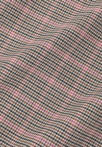 Tkanina s hnědým, bílým a černým vzorem houndstooth s růžovými akcenty, vykazující hladkou texturu a tkaný design.