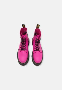 Stivaletti alla caviglia in pelle fucsia brillante con lacci neri, punta rinforzata, cuciture gialle e una linguetta sul retro per una facile vestibilità.