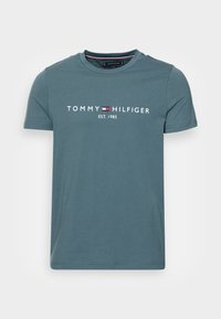 Tyrkysové bavlněné tričko s kulatým výstřihem, krátkými rukávy a bílým potiskem "TOMMY HILFIGER EST. 1985" na hrudi.