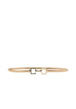 Ceinture fine en or avec une petite boucle rectangulaire comportant deux découpes carrées, posée à plat sur un fond blanc.