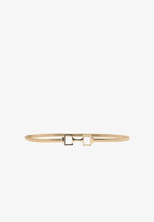 Ceinture fine en or avec une petite boucle rectangulaire comportant deux découpes carrées, posée à plat sur un fond blanc.