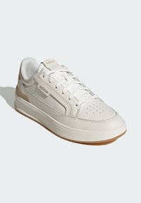 Zapatillas de cuero blanco con un acabado liso, detalles tonales, puntera perforada y una suela de goma natural. Presenta cordones blancos y logotipo.