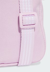 Bolso de color púrpura claro con una tela texturizada, una correa de hebilla suave y detalles de costura sutiles. Los bordes redondeados realzan su diseño.