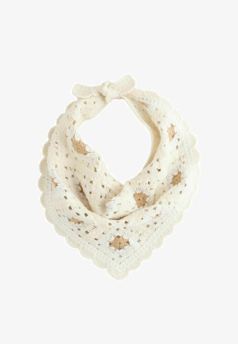 Bandana de ganchillo color crema con estampados de estrellas beige y bordes festoneados atada con un lazo en la parte superior.