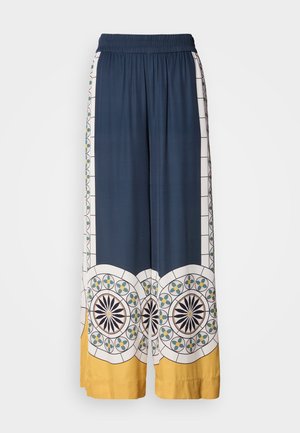 Námořnické široké kalhoty s elastickým pasem, zdobené geometrickými vzory v bílé, zelené a žluté barvě podél lemů a stran.