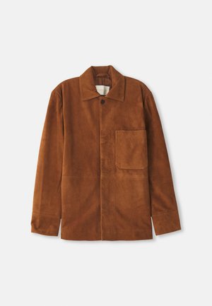 Lange braune Wildlederjacke mit langen Ärmeln, Kragen, einer Knopfschließe, vorderer Brusttasche und geradem Saum auf weißem Hintergrund.