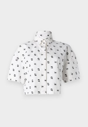 Camicetta corta a maniche corte in cotone bianco con un motivo grafico ripetuto in nero di volti che indossano occhiali da sole. Colletto alla camicia.