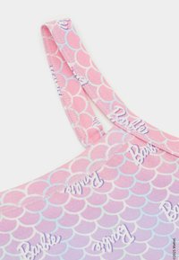 Růžový a levandulový top bez rukávů s vroubkovaným vzorem, na kterém je nápis "Barbie". Vyrobeno z měkké tkaniny s tenkými ramínky a šitými detaily.