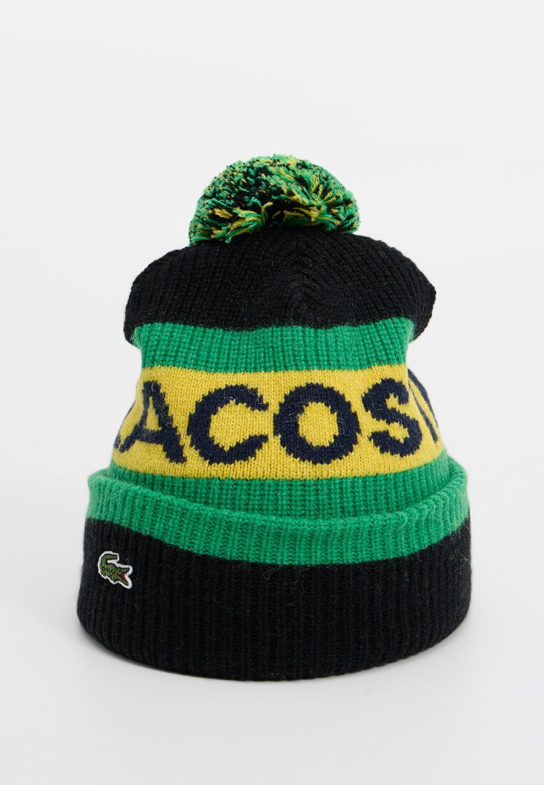 Gebreide beanie in zwart, groen en geel. Voorzien van "LACOSTE"-tekst en een meerkleurige pompon bovenop. Inclusief logo-patch aan de zijkant.