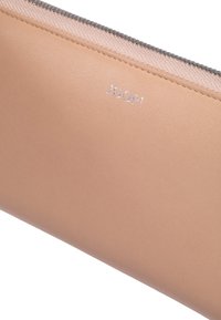 Portafoglio in pelle color tan con superficie liscia, dotato di un logo argento "JOOP!" e una zip a contrasto lungo il bordo superiore.