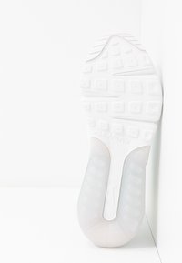 Semelle de sneaker blanche avec des motifs de grip texturés et un logo "Air Max" visible. Comprend une section claire et rembourrée pour le confort et le soutien.