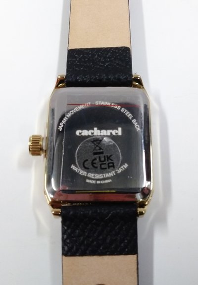 Polshorloge met gouden kast en zwarte leren band, achterkant getoond met de tekst "cacharel", waterbestendig 3 ATM, en "Japan movement".
